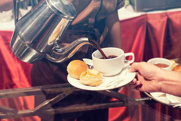 Blurred for Background.The waitress filed a glass of white coffee with the Bread stuffing with dried shredded pork between the brake and the brake food background.