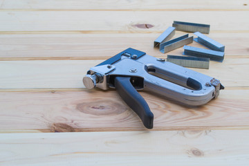 Construction stapler on a wooden table.