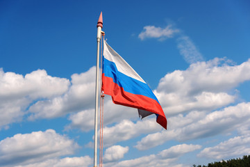 Russian flag flies on the flagpole against the sky. Freedom is independence and patriotism.