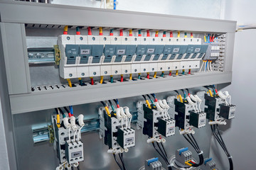 Series of Fuse holders, contactors or magnetic starters with front additional contacts, cylindrical capacitors in the electric reactive power compensation Cabinet. Wires are connected to the project.