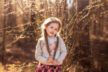  portrait of  beautiful little girl with long hair in the woods on nature
