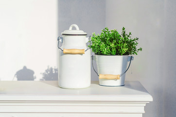 Enameled metal bucket and jar white color on the shelf. Pastel colors.