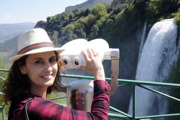 The girl admires Marmore waterfalls with binoculars