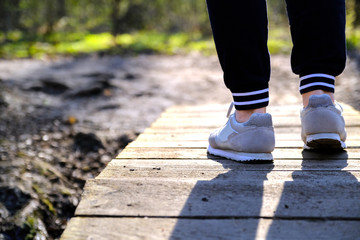 Jogging in sneakers on the bridge in the Park. Sport, Health and physical culture concept.