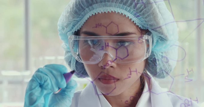 Close up scene video of Asian female scientist writing chemical bonding on glass board.