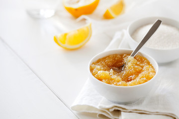 Trendy healthy homemade citrus lemon jam or confiture in a bowl on a white wooden background with copy space for text.Delicious dessert for Breakfast. Fruit preservation.Horizontal orientation