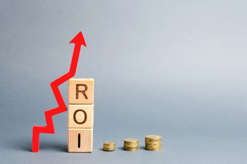 Wooden blocks with the word ROI and arrow up. High level of business profitability. Return on investment, invested capital, rate. Success. Growth. Profitability. Analytics. Report