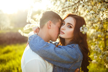 Beautiful loving couple in the blooming gardens. Wedding concept. Great sunset light. Lovely newlyweds.