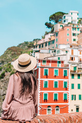 Fototapeta premium Young woman with great view at old village Riomaggiore, Cinque Terre, Liguria