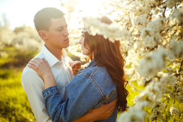 Fototapeta premium Beautiful loving couple in the blooming gardens. Wedding concept. Great sunset light. Lovely newlyweds.