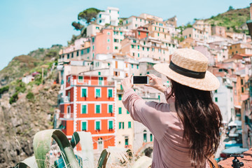 Young woman taking selfie background beautiful old italian village, Cinque Terre, Liguria