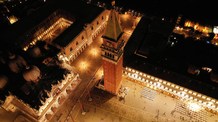 Aerial drone night shot of iconic illuminated Saint Mark's square or Piazza San Marco featuring...