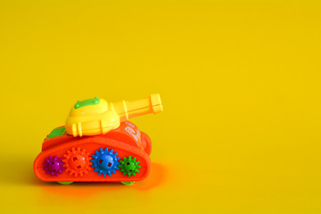 Toy tank isolated on a yellow background.