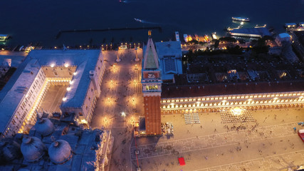 Aerial drone night shot of iconic illuminated Saint Mark's square or Piazza San Marco featuring...