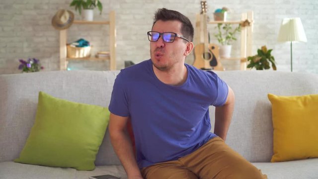 Portrait unhealthy man feeling discomfort hemorrhoid pain sitting on the couch