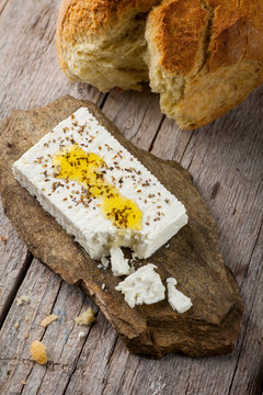 feta cheese on a stone with bread and olive oil