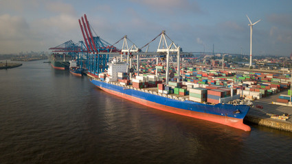 Container-Terminal mit Schiffen im Hafen von Hamburg bei Sonnenaufgang