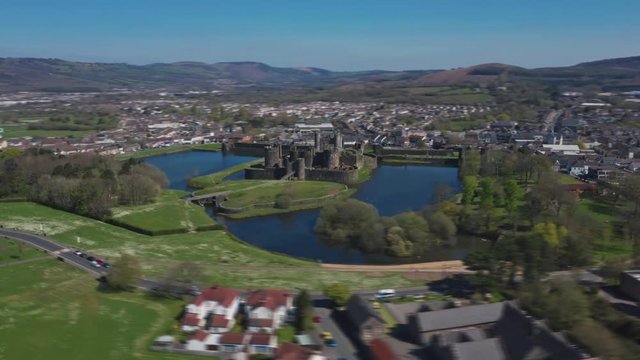 Wide aerial orbit hyperlapse of Caerphilly Castle north of Cardiff, South Wales. Filmed on a Spring April morning with blue skies and bright sunshine on the DJI Mavic 2 Pro from DNG raw stills.