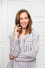 Portrait of beautiful smiling brunette in pajamas