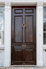 Charleston doorway dark door with white frame trim shows age and vintage of the town city with brass door knocker 