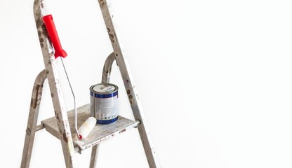painting roller with color can on metal ladders. house walls painting concept.