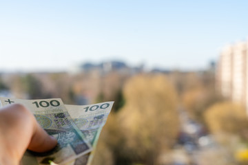 Banknotes held in the palm of your hand symbolizing the social distribution. In the background you...