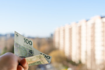 Banknotes held in the palm of your hand symbolizing the social distribution. In the background you...