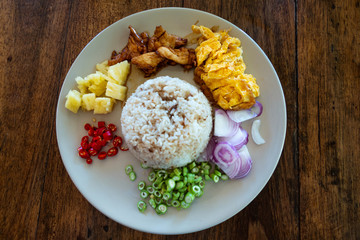 Fried rice with tofu and chicken, top view, dark background. Healthy food concept.