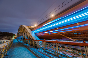 High-speed train with motion blur on the background of the railway bridge in the dark