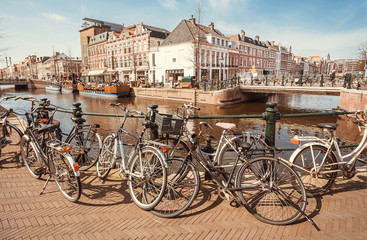 Bicycles parked on bridge through river of historical european town. the Netherlands.