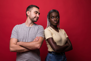 Obraz premium Young mixed race couple having a quarrel isolated on red background