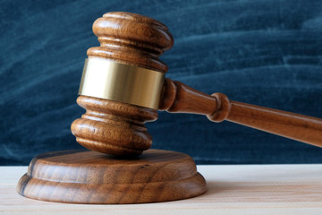 Judges gavel on the background of a black school board with chalk stains, copy space. Concept of...