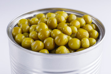 Canned green peas in a iron can on white background