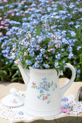 Vergissmeinnicht-Blumenstrauß in Teekanne als Dekoration