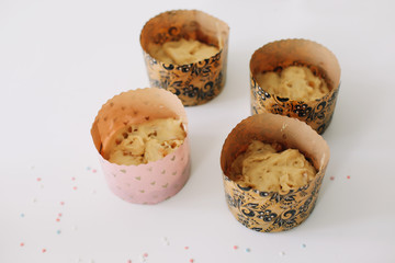 Baking  pastry in the kitchen. Cooking cakes or bread concept. Dough for easter cake in forms over white background. Spring cooking theme. Top view, copy space.