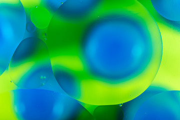 oily drops  in water with colorful background, close-up 