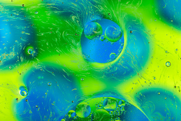 oily drops in water with colorful background, close-up