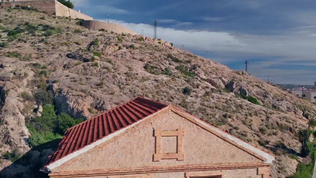 Drone flight ascending the monastery with view over Orihuela in the sunshine and blue sky.