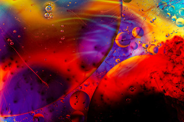 oily drops  in water with colorful background, close-up 