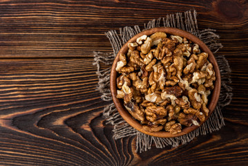 Walnut on dark wooden background.