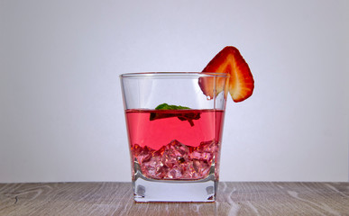 A refreshing drink of strawberry juice with a mint leaf.  Were added to the drink ice.