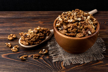 Walnut on dark wooden background.