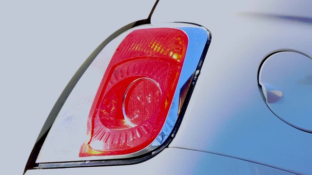 Hazard backlight flashing of a mini cooper white car, close up shot