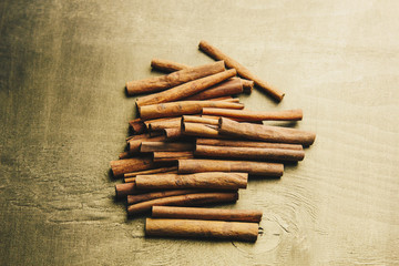 a bunch of whole sticks of fragrant cinnamon on a wooden rural table. copyspace. composition of seasoning and slide flavoring aromatic spice. close-up. top view