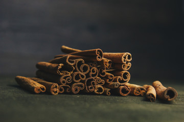 a bunch of whole sticks of fragrant cinnamon on a wooden rural table. copyspace. composition of seasoning and slide flavoring aromatic spice. close-up. front view