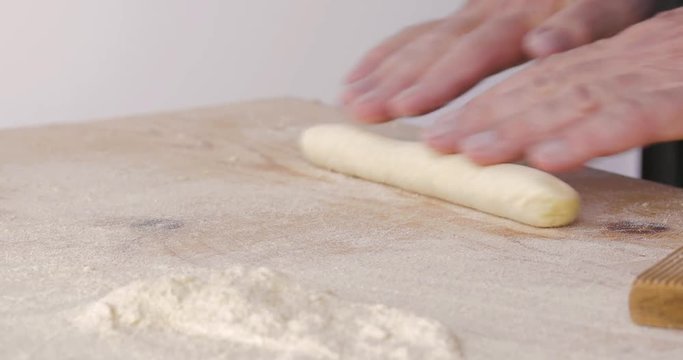 Gnocchi tradizionali di patate, uova e farina, fatti in casa su un tagliere di legno.