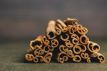 a bunch of whole sticks of fragrant cinnamon on a wooden rural table. copyspace. composition of seasoning and slide flavoring aromatic spice. close-up. front view