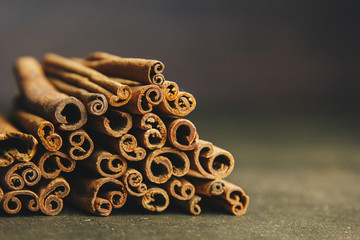 a bunch of whole sticks of fragrant cinnamon on a wooden rural table. copyspace. composition of seasoning and slide flavoring aromatic spice. close-up. front view