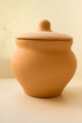 clay pot stands on a table with a cracked lid