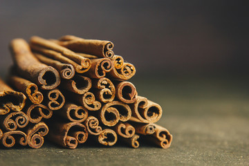 a bunch of whole sticks of fragrant cinnamon on a wooden rural table. copyspace. composition of seasoning and slide flavoring aromatic spice. close-up. front view